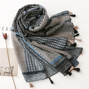 Detailed close-up of mixed geometric patterns and leopard print scarf with fringe tassels