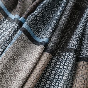 Detailed close-up of bohemian pattern scarf with leopard print and geometric tassel texture