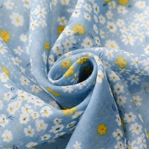 Detail of light blue floral cotton scarf fabric with daisy print and soft texture