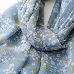 Detail of light blue floral scarf showing breathable cotton linen texture and daisy prints
