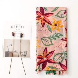 Bohemian floral scarf with tropical lilies and tassels on a minimalist white backdrop