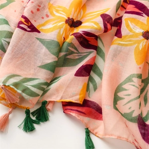 Close-up of tropical floral print beach shawl with pink tassels and cotton-linen texture
