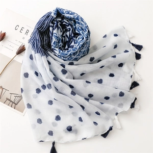Detailed view of blue and white floral scarf with stylish tassels and geometric patterns
