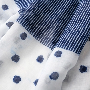 Macro detail of breathable cotton-linen fabric with blue stripes and polka dots