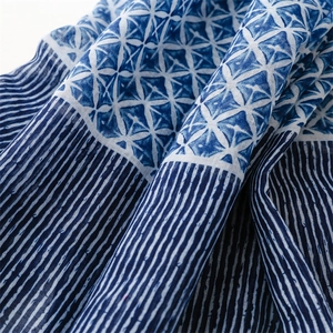 Detailed close-up of blue and white geometric floral print on soft cotton linen scarf