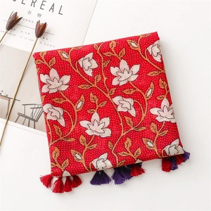 Gros plan d'un châle en coton à fleurs rouges avec franges et motif vintage chic