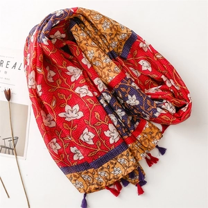 Châle à imprimé floral ethnique avec glands colorés sur un fond blanc minimaliste
