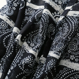 Macro view showing black paisley pattern and floral print on thin cotton linen fabric