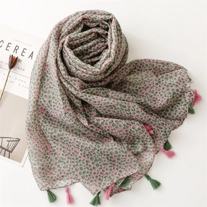Close-up of floral print scarf with soft pink and green tassels on thin fabric