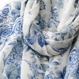 Gros plan des motifs floraux bleus sur écharpe en coton et lin montrant la texture