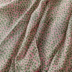 Detailed macro view of pink cotton linen fabric with delicate green floral pattern