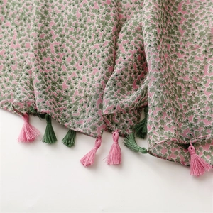 Close-up of floral cotton-linen scarf fabric with decorative fringe tassel details