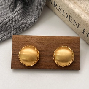 Brushed gold geometric square earrings with matte vintage texture in a still life layout