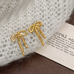 Elegant gold vintage bow-knot stud earrings displayed on a soft grey knitted texture