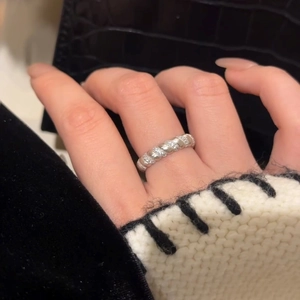 Macro detail of silver twisted rope ring with crystals on hand and black leather