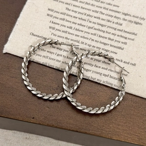 Orecchini a cerchio intrecciati argento con design geometrico e stile minimalista