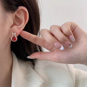 Elegant chalcedony bow earrings with red gemstone and zircon inlay on female model