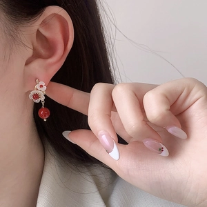 Elegant camellia pearl earrings with white resin petals and vibrant red beads