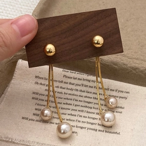 Detailed view of champagne pearl tassel earrings with golden chain and ball stud