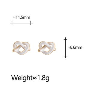 Detail view of heart knot earrings with white enamel finish and dimensions 11.5mm x 8.6mm