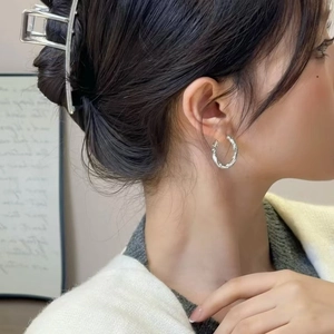 Boucles d'oreilles créoles torsadées argentées pour femmes avec texture métallique