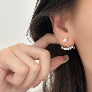 Detailed view of elegant bow-style pearl earrings with shimmering zircon jacket curves