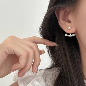 Close-up of bow pearl and zircon stud earrings on model for elegant bridal or daily style