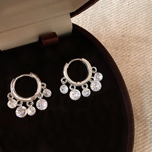 Macro shot of silver zircon tassel earrings featuring five sparkling round-cut stones