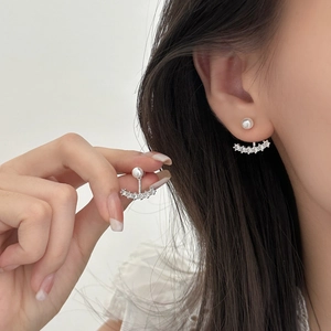 Detailed view of elegant pearl and cubic zirconia ear jacket earrings with silver metal base