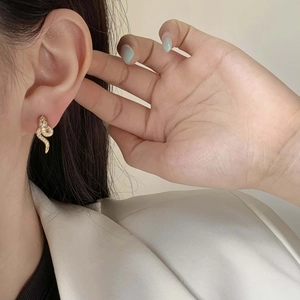 Elegant gold snake-shaped earrings with micro-paved crystals for a sophisticated look