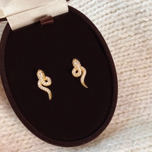 Elegant gold snake earrings with sparkling crystals in a premium jewelry gift box