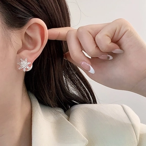 Boucles d'oreilles flocon de neige en argent avec zircons portées par un mannequin
