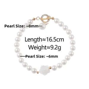 Detail eines Perlenarmbands mit 8mm/6mm weißen Perlen und weißem Rosenanhänger