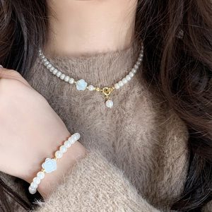 Elegantes Perlenhalsketten und Armband Set mit weißen Blumen und Goldakzenten