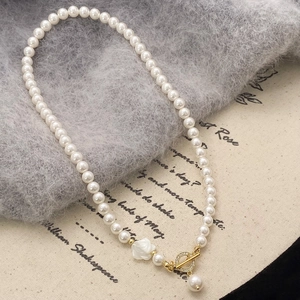 Detailansicht der Perlenkette mit weißer Blumenform und goldenem OT-Verschluss-Design
