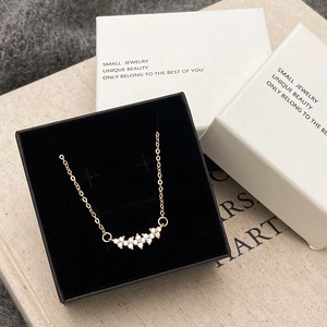Gold necklace with curved zircon pendant presented in a premium black jewelry box