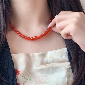 Elegant beaded necklace with red agate stones on model with embroidery dress