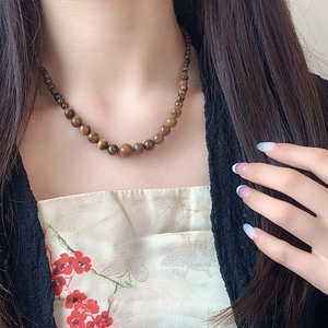 Detail of tiger eye stone necklace worn by model showing natural brown gradient beads