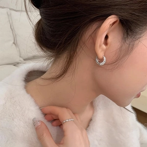 Elegant silver double-hoop zircon earrings and diamond ring worn by a female model