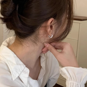 Close-up of elegant double hoop pavé cubic zirconia earrings worn by a model