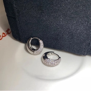 Macro detail of silver hoop earrings featuring micro-pave cubic zirconia and polished finish