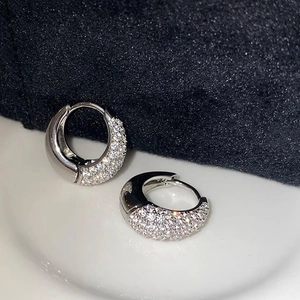 Close-up of luxury silver hoop earrings with micro-paved sparkling cubic zirconia stones