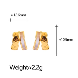 Detailed view of geometric C-shaped quilted gold earrings with white shell inlay