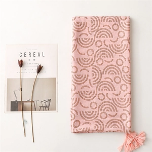 Pink cotton linen scarf with brown geometric patterns and tassel edges on white background