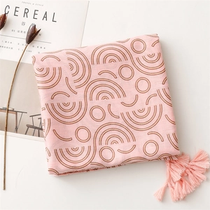 Detail of pink cotton linen scarf with geometric circle patterns and fringe tassels