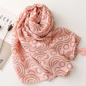 Detail of pink cotton-linen scarf with brown geometric circles and fringe tassels