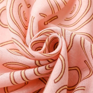 Close-up of pink cotton linen fabric with abstract brown circle patterns and soft texture