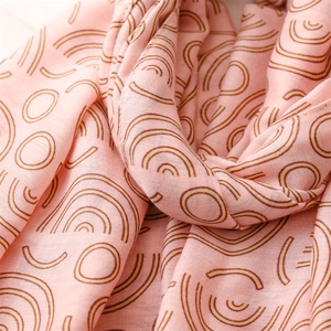 Detail of pink cotton scarf with bohemian geometric patterns and soft woven texture