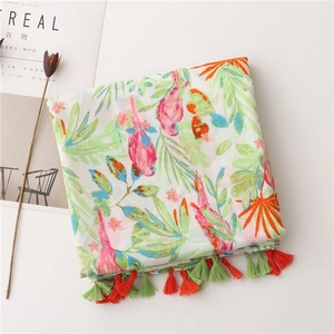 Detail of tropical bird and floral print on lightweight linen scarf with fringe trim