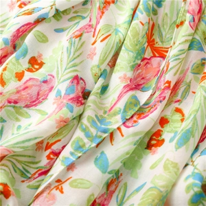 Close-up of lightweight linen scarf featuring vibrant tropical bird and floral prints